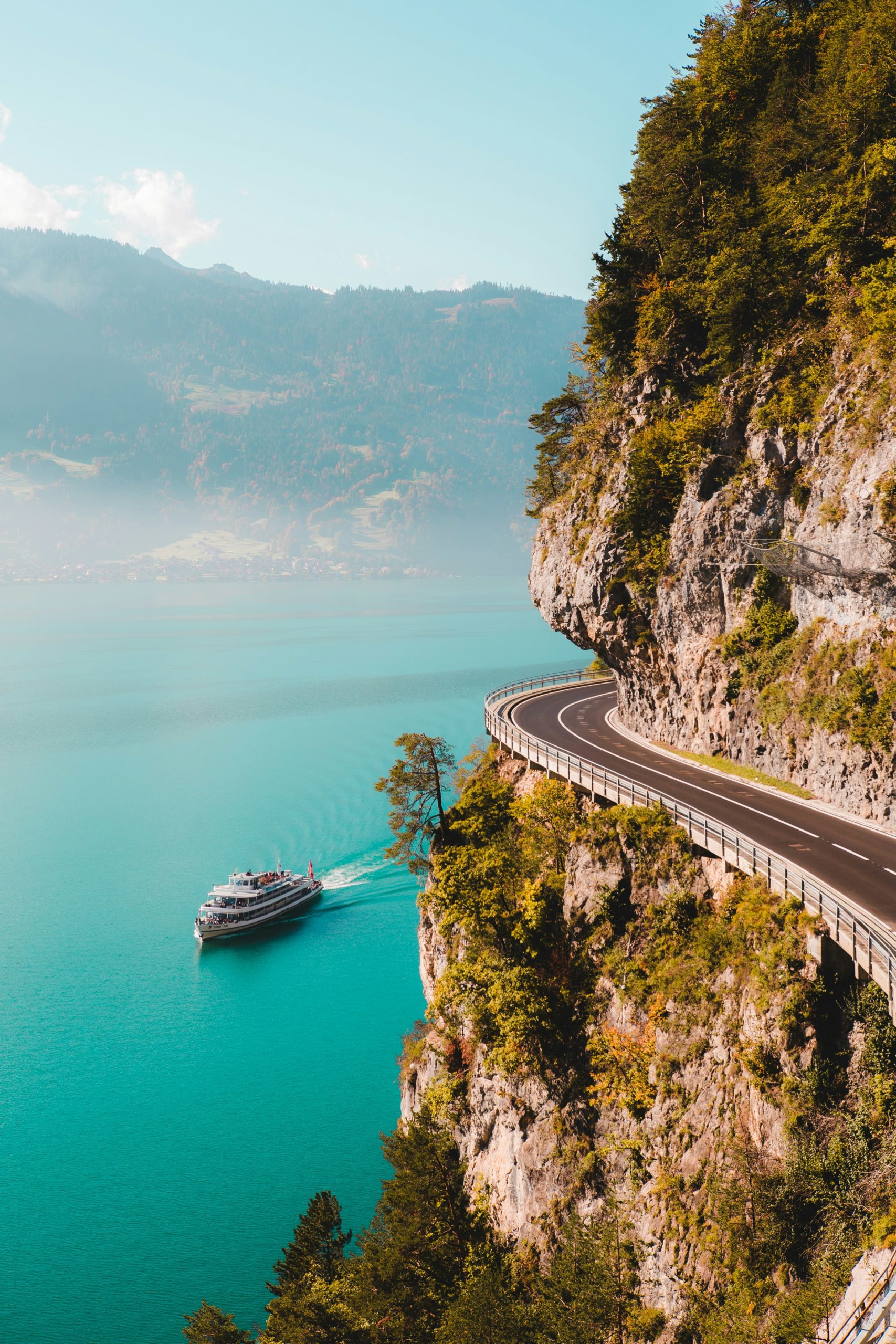 Mountain road winding above blue water