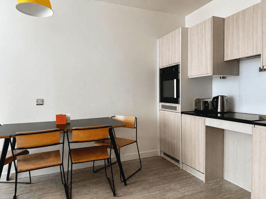 Open-plan kitchen and dining area in the Staycity Manchester Piccadilly two-bedroom apartment.