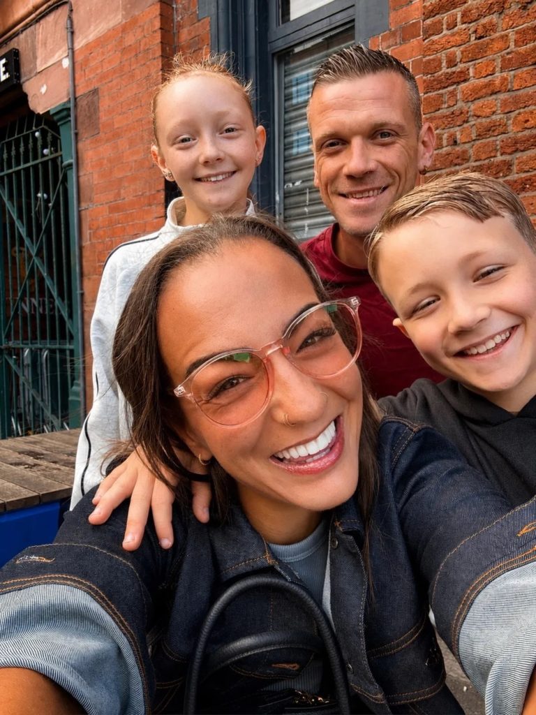 Family of four smiling together during an Access Manchester family city break.