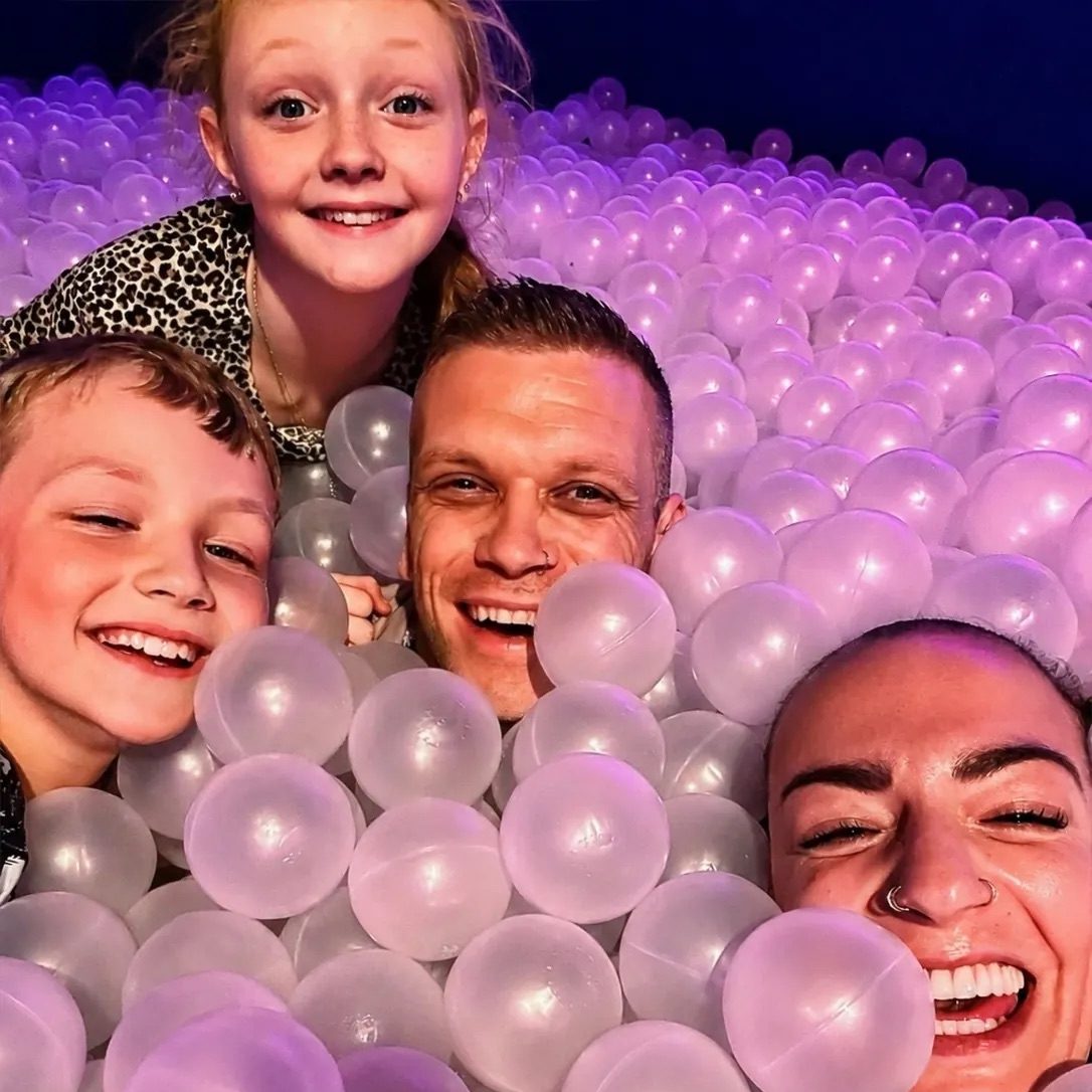 Family of four enjoying the purple ball pit at Bubble Planet Manchester during an accessible family city break.