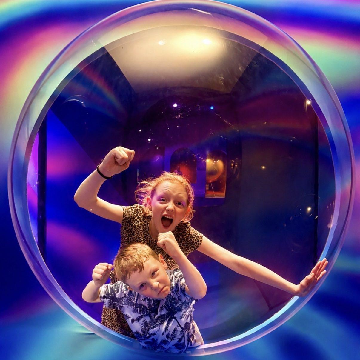 boy and girl pretending to break out of a bubble at Bubble Planet Manchester during an accessible family city break.