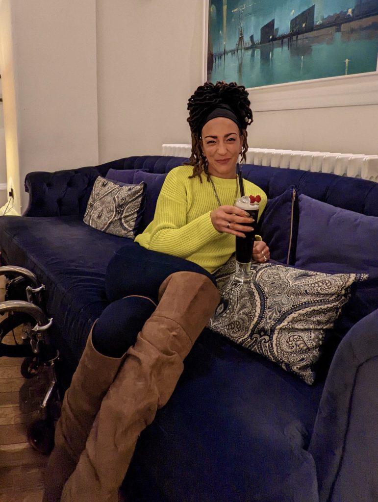 Luiz Faye relaxing on a purple sofa at Titanic Hotel Belfast.