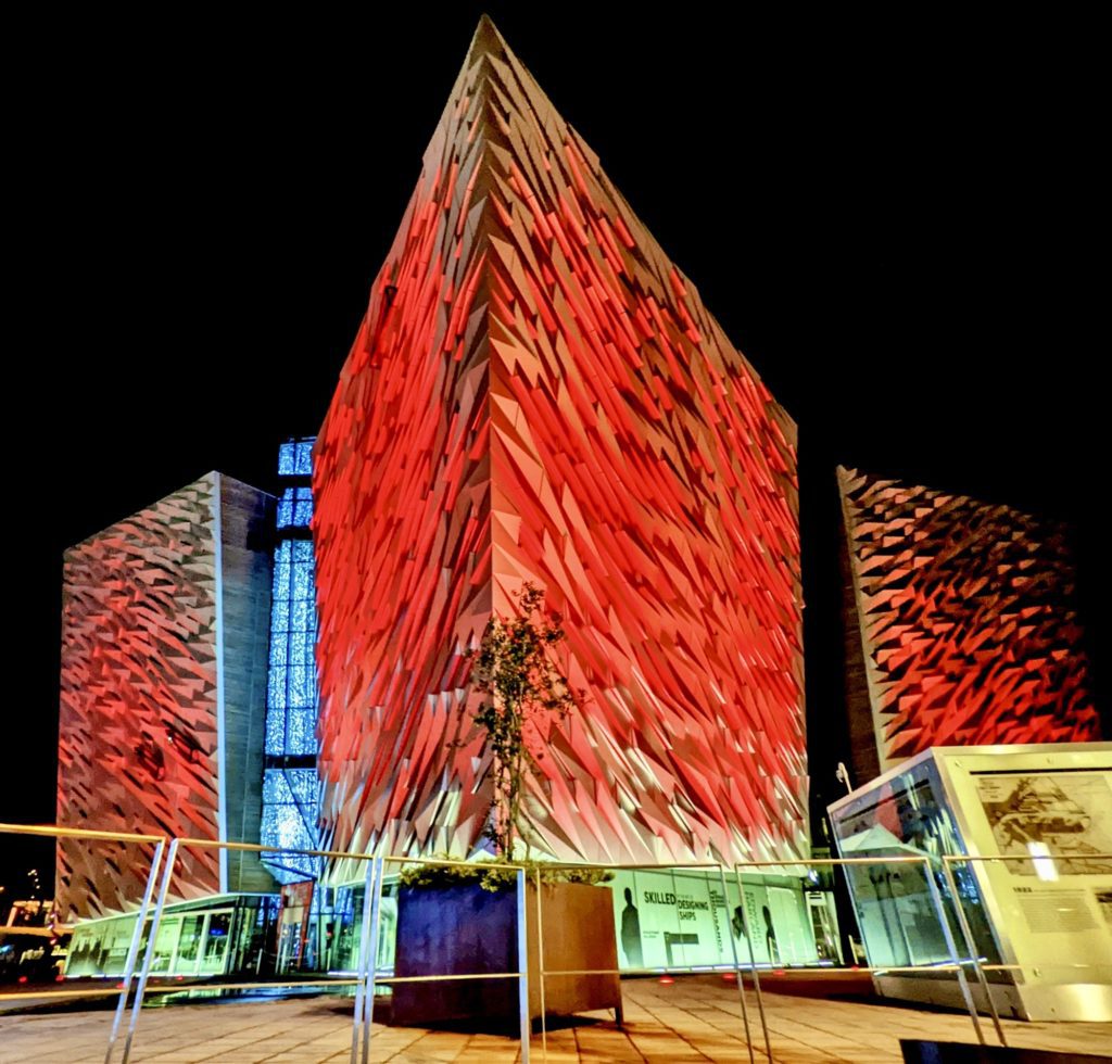 Titanic Belfast illuminated red at night.