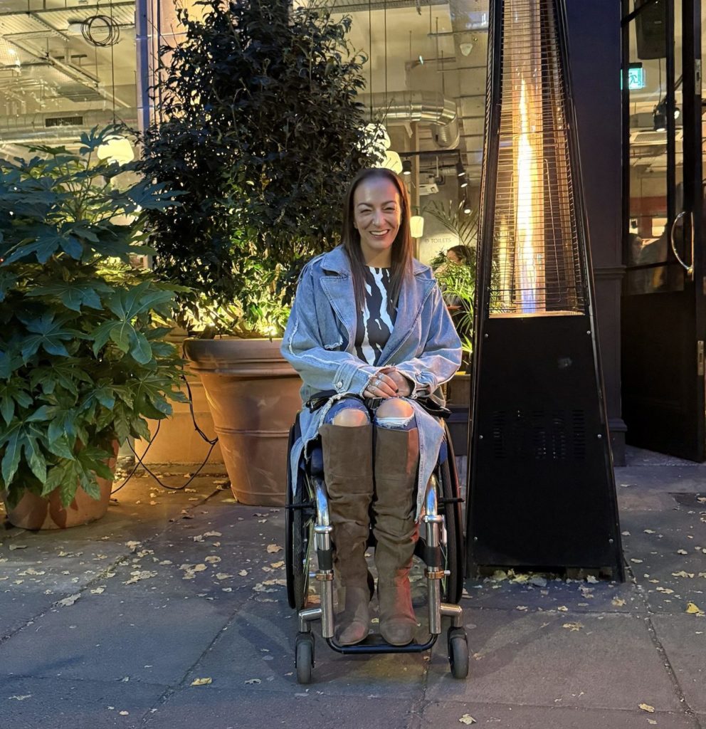 Luiz Faye seated outside Amelia Hall beside a patio heater.